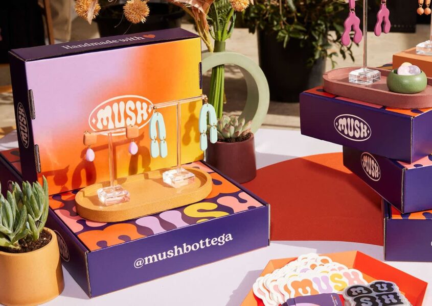 Colorful trade show booth displaying branded jewelry packaging boxes used as both packaging and product displays.