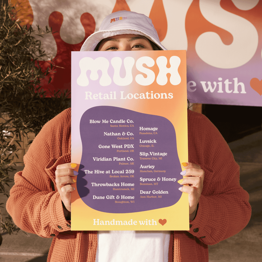 A woman holding a bold orange and purple poster featuring a store’s retail locations