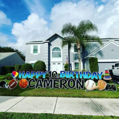 Large birthday yard sign in front of a suburban home spelling out Happy 10th Birthday Cameron with sports-themed graphics