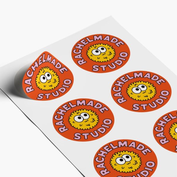 Cartoon-style design studio logo printed on stickers, elements of branding