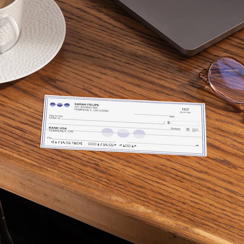 a custom business check on a wooden table