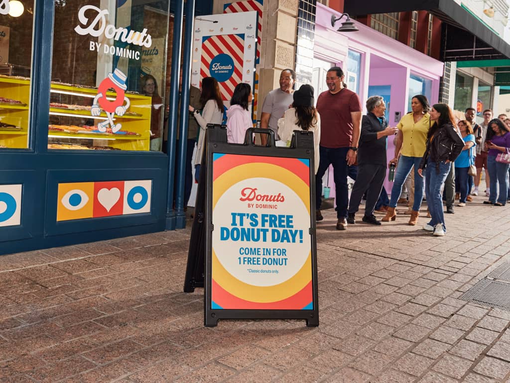 Donut company A-frame signage using brand colors, brand elements