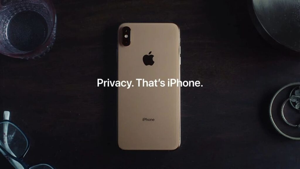 gold iPhone on a dark wooden table with text “Privacy. That’s iPhone.” example of confident minimalist brand voice