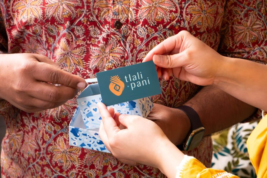 Hands exchanging branded business cards with logo, branding elements