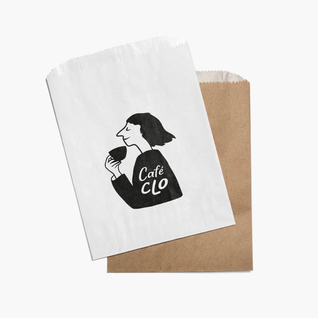 An illustrated cafe logo of a woman drinking a coffee printed on a paper bag