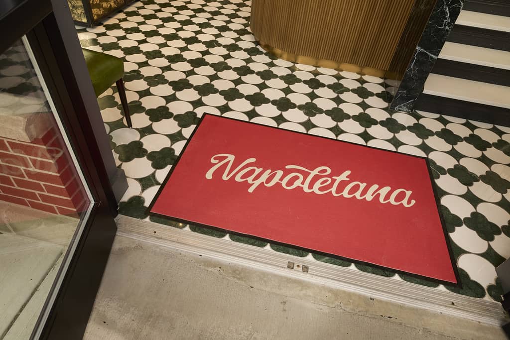 Restaurant brand name and logo on a storefront floor mat, brand elements