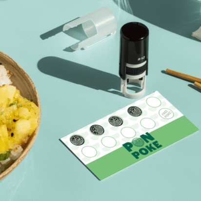 Custom stamp on a loyalty card beside a fresh poke bowl on a mint green background