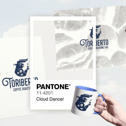 Branded packaging and mug in Pantone 11-4201 Cloud Dancer, held against a cloudy sky background