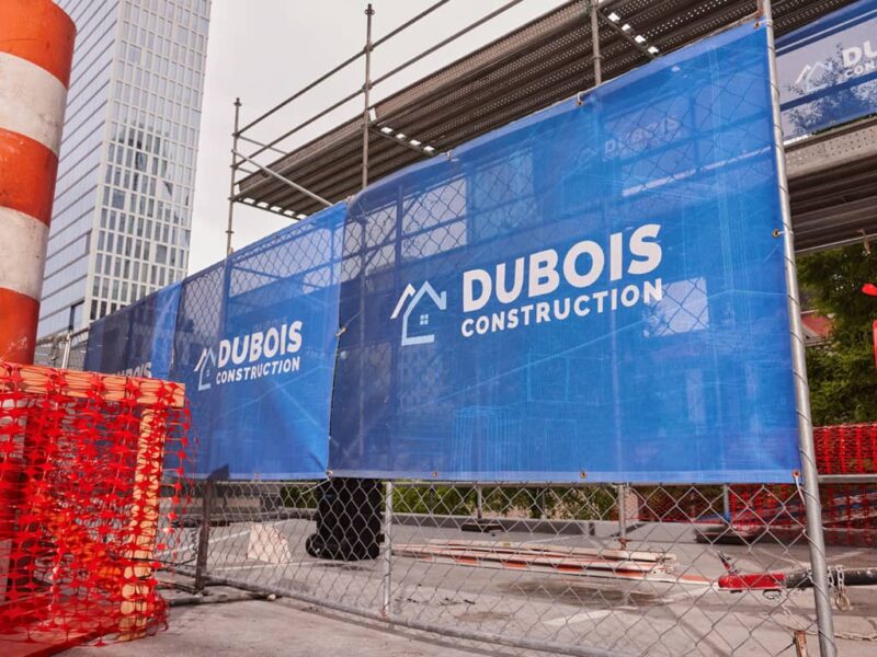 A blue mesh banner advertising a construction company