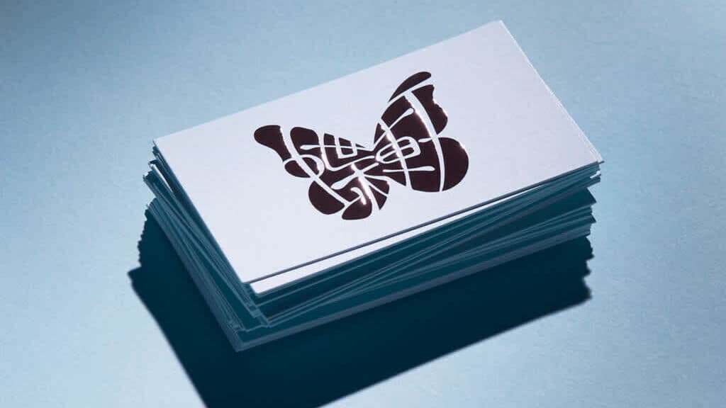 Business card stack with stylized butterfly logo