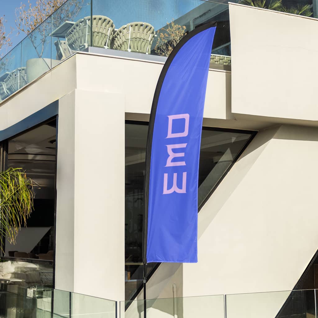 A blue feather flag outdoors advertising a cosmetics brand