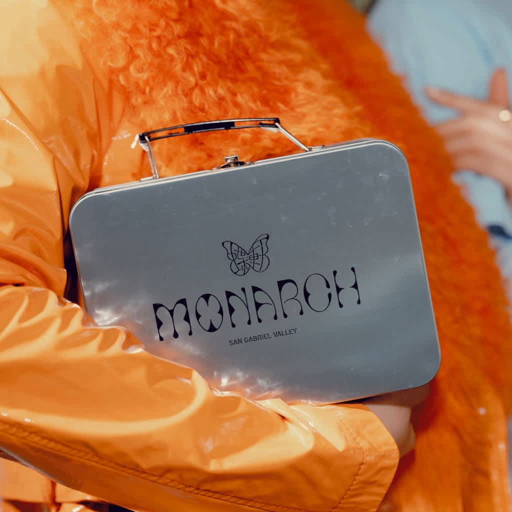 branded custom metal lunchbox carried by someone in orange coat