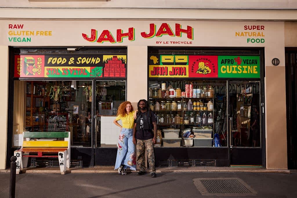 Business owners standing outside an Afro vegan cuisine storefront design