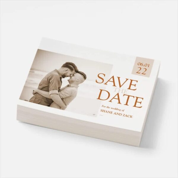 A pile of save the date cards with an image of a couple on the front, with minimal copy outside of "Save the date" with the date and the couple's names.
