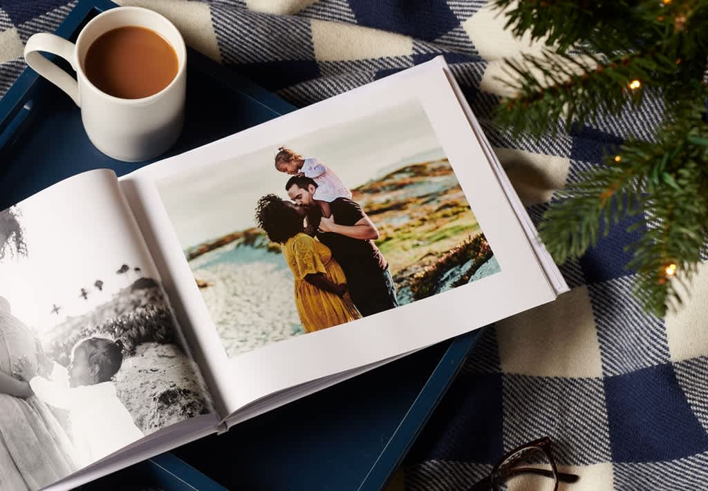 A custom photo book opened up to a photo of a family at the beach