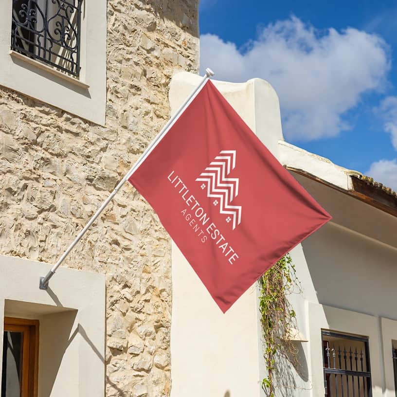 estate agent wall flag with logo hanging on pole outside building