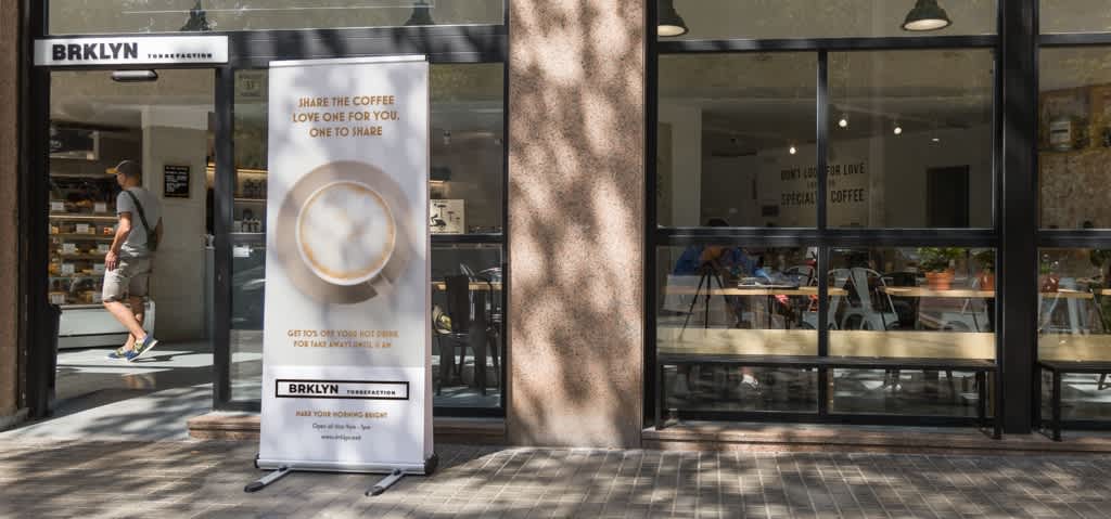 promotional coffee banner outside of cafe storefront