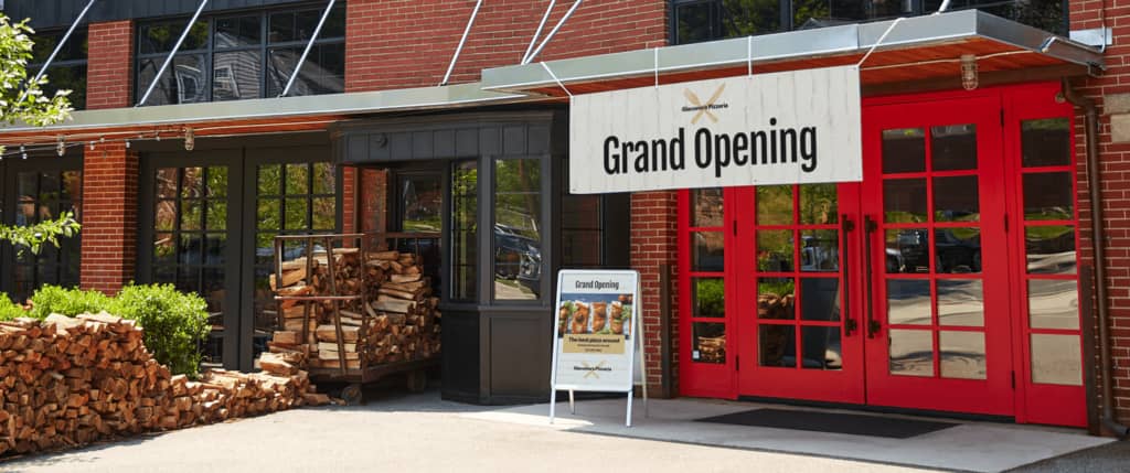 A banner and A-frame sign outside a restaurant