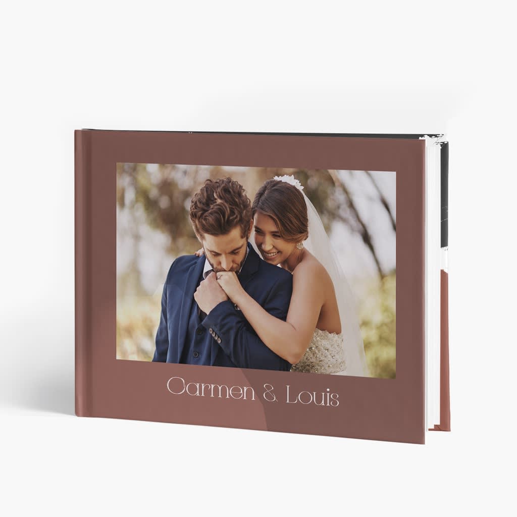 Wedding photobook with groom kissing bride’s hand on the photo cover