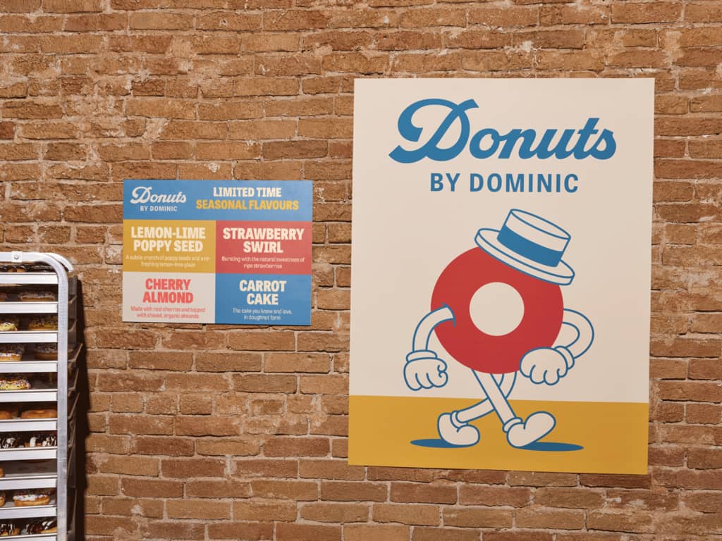 Posters for a donut shop on a brick wall