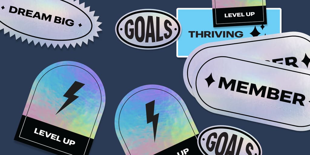Holographic style stickers with black impact font features inspirational phrases, like “Goals” and “Dream Big”