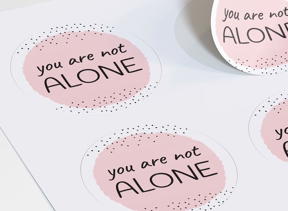 Circular stickers with “you are not alone” on them
