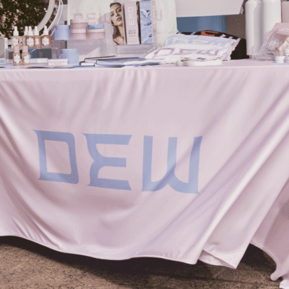 Tradeshow booth display with branded tablecloth and promotional products showing tradeshow giveaway ideas for event marketing