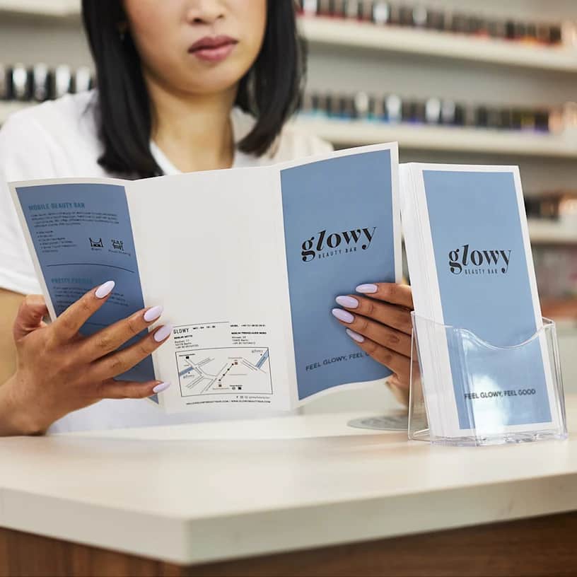 woman holding tri-fold brochure for a beauty business