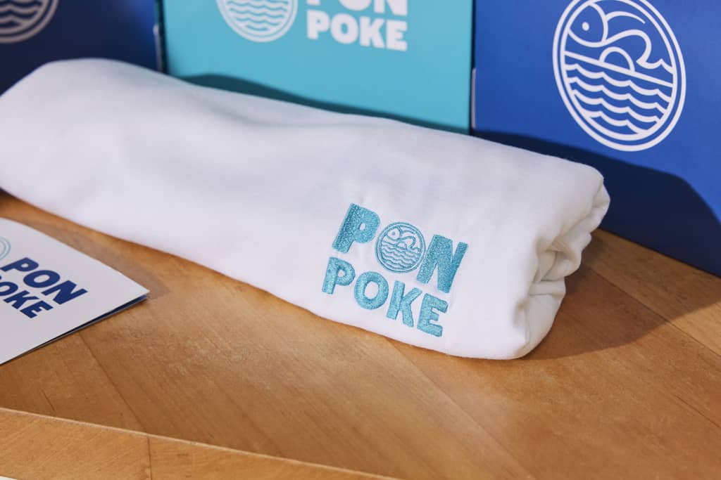Embroidered branded T-shirt for a poke restaurant’s branded merch collection