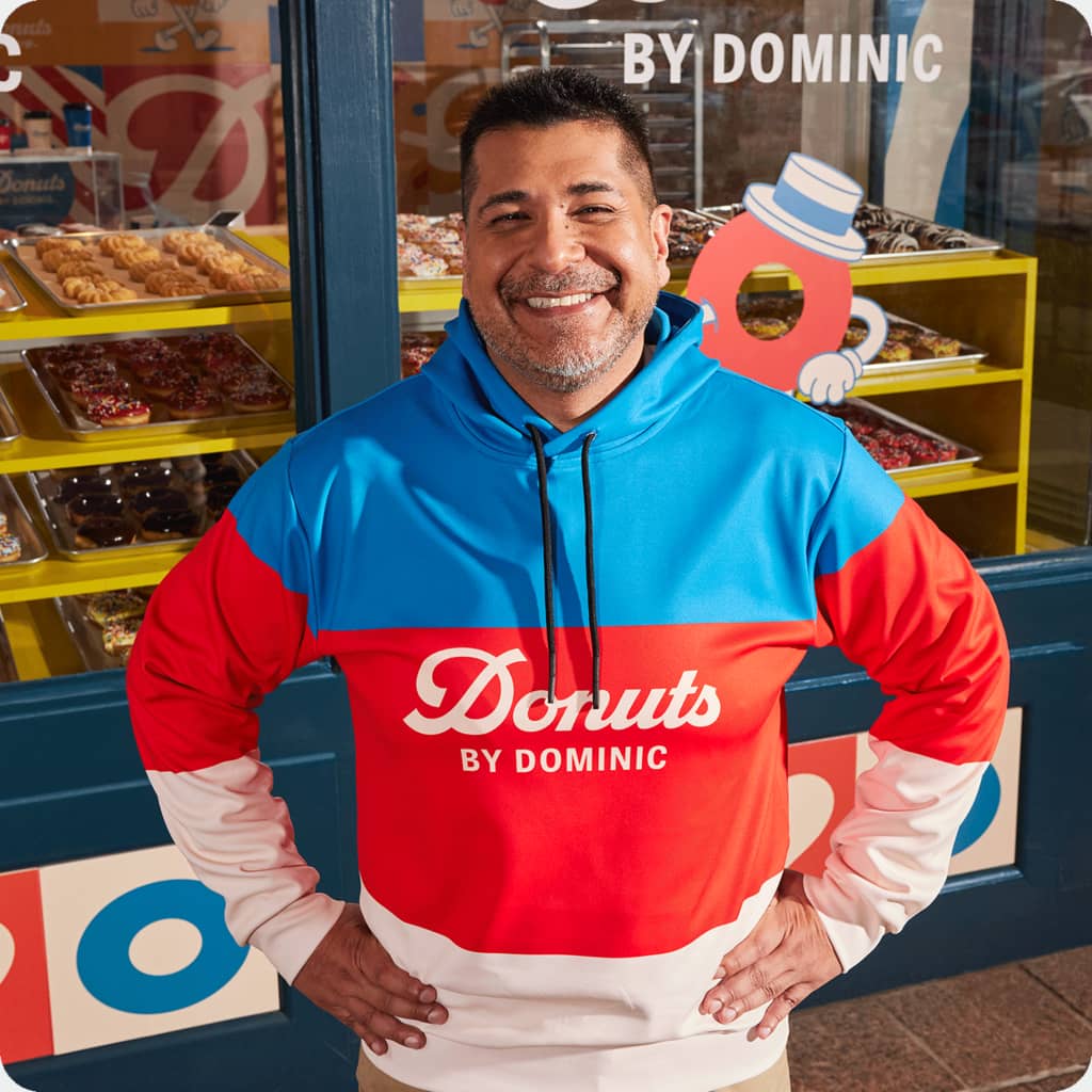 Employee wearing a branded striped colorblock hoodie design with a wordmark logo on the front