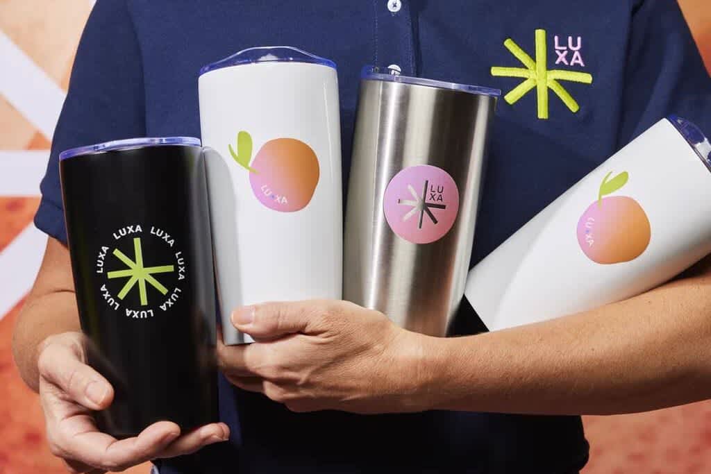 A woman carrying 4 fruity-branded water bottles.