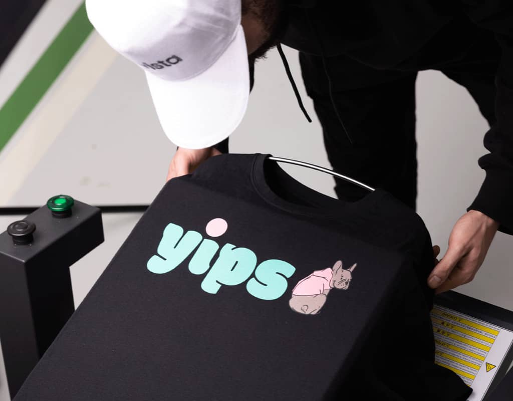 A black T-shirt being printed with a pink and blue design