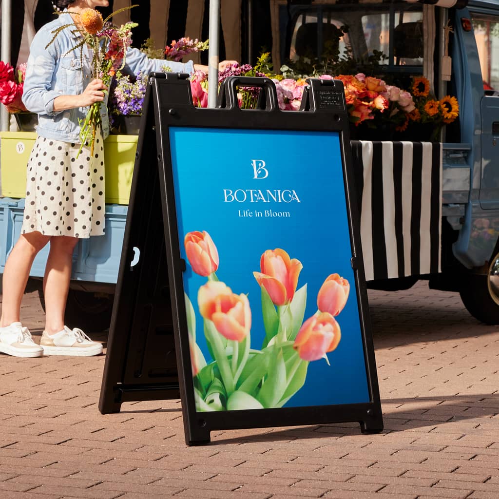 A-frame sign promoting floristry business in front of their van