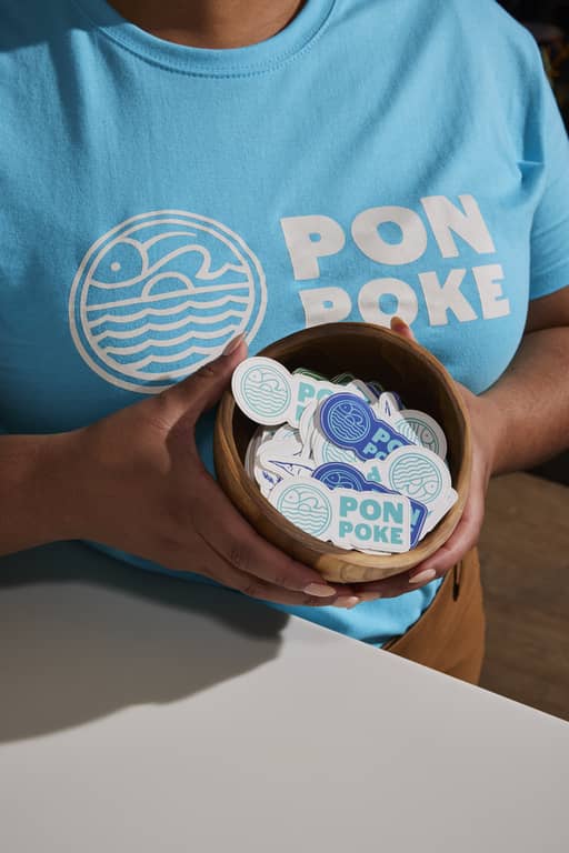 Vibrant, bright blue Pon Poke stickers used as promotional merch