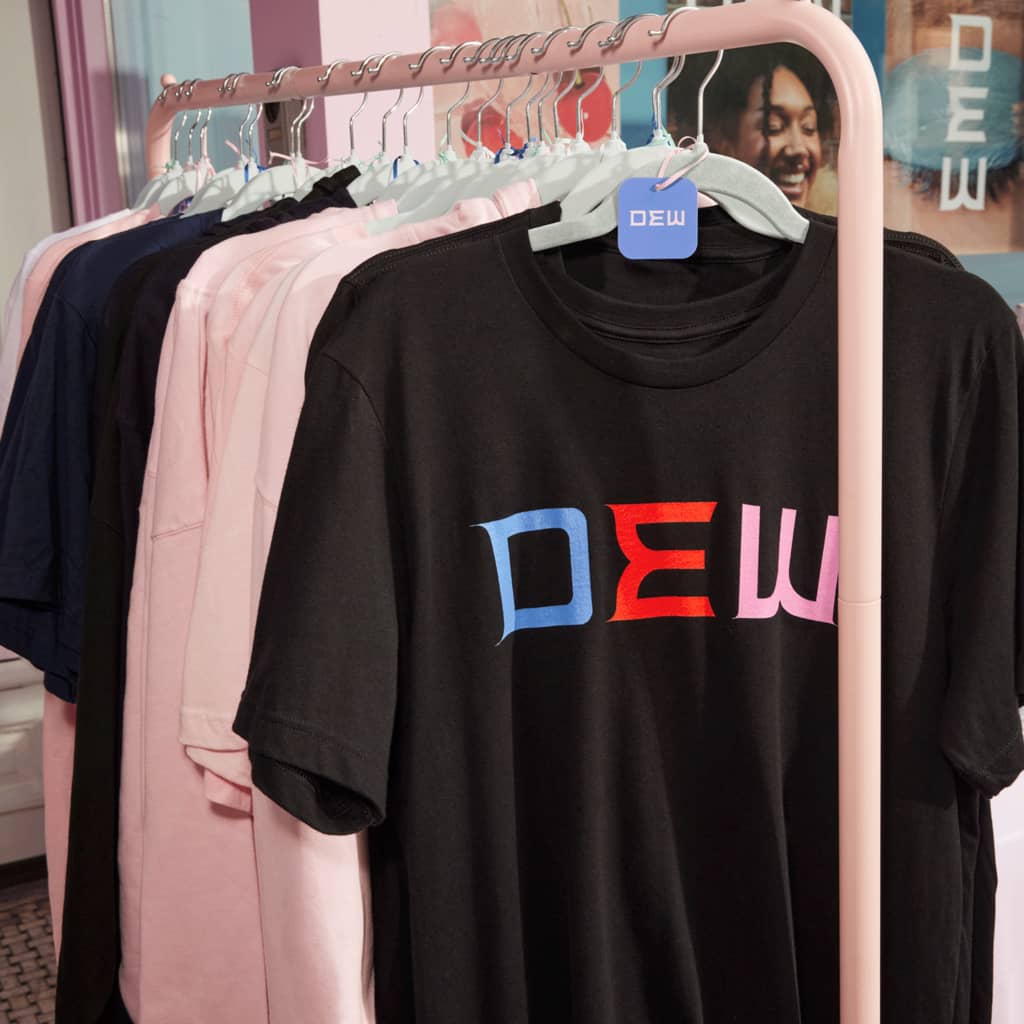A rail of black and pink T-shirts with a brand logo printed on the chest