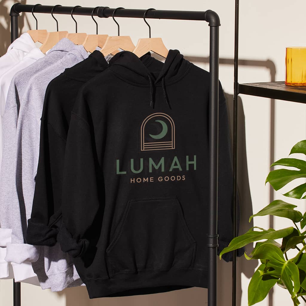 Black, gray and white branded hoodies with the brand logo on the front hanging on a retail rack