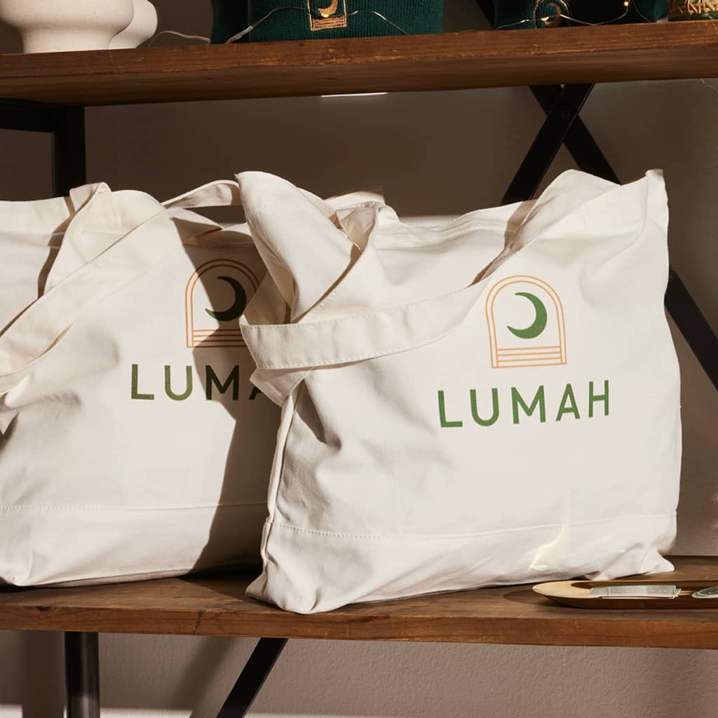 Branded tote bags with a green brand logo and moon design, branded merch
