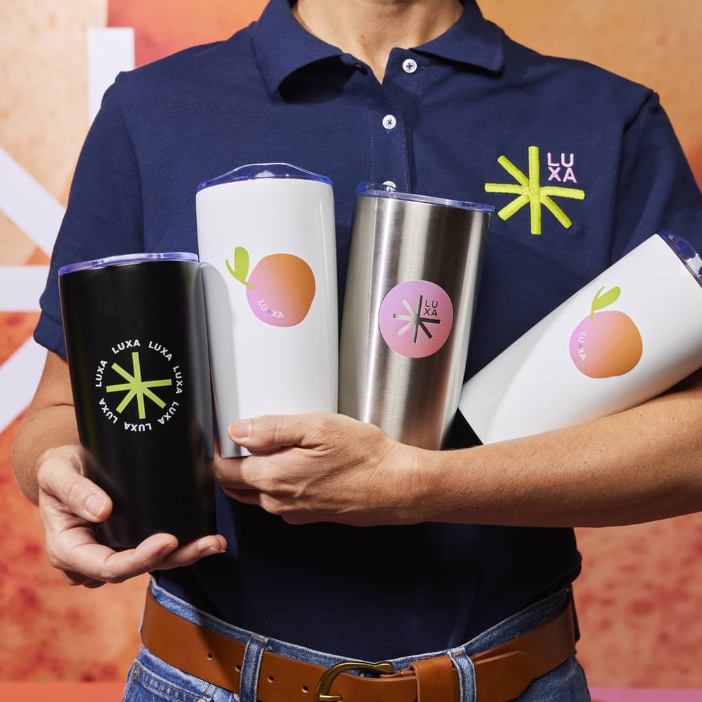 An employee holding a selection of branded insulated tumblers with different designs