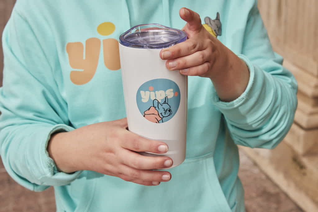Yips branded water tumbler with dog illustration on the front