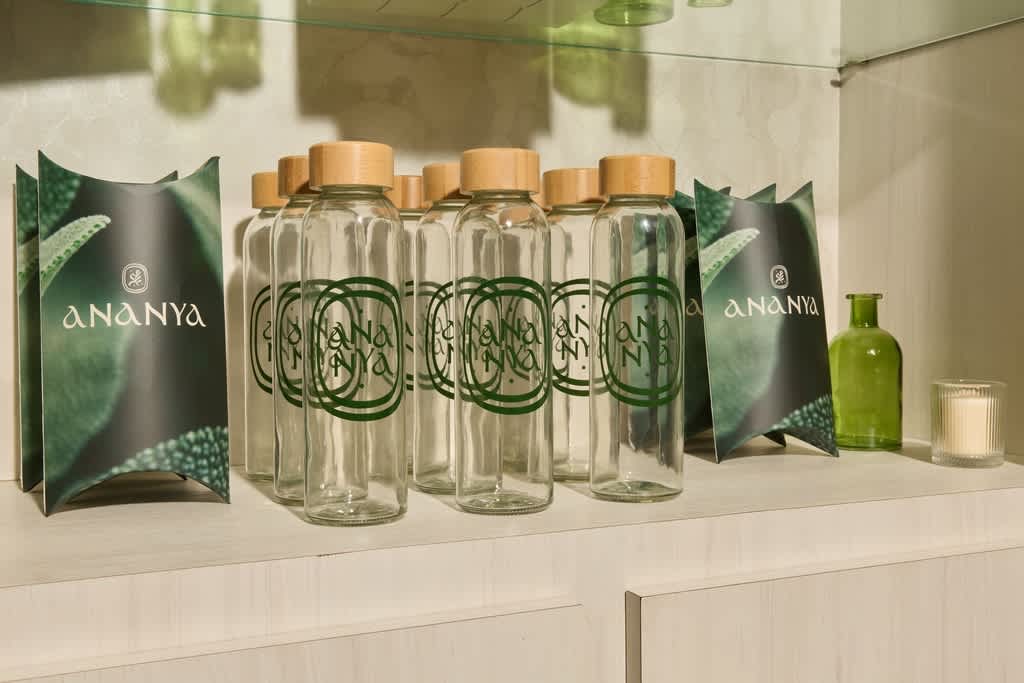A shelf with green branded box packaging and bottles