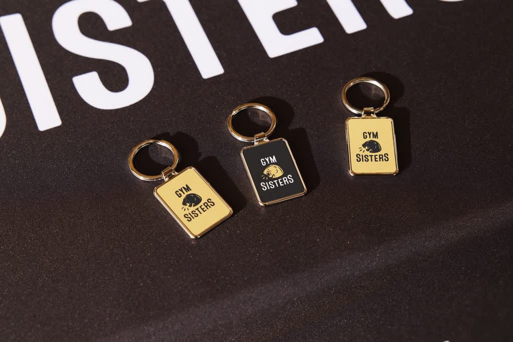 A black table with black and yellow branded keyrings advertising a gym