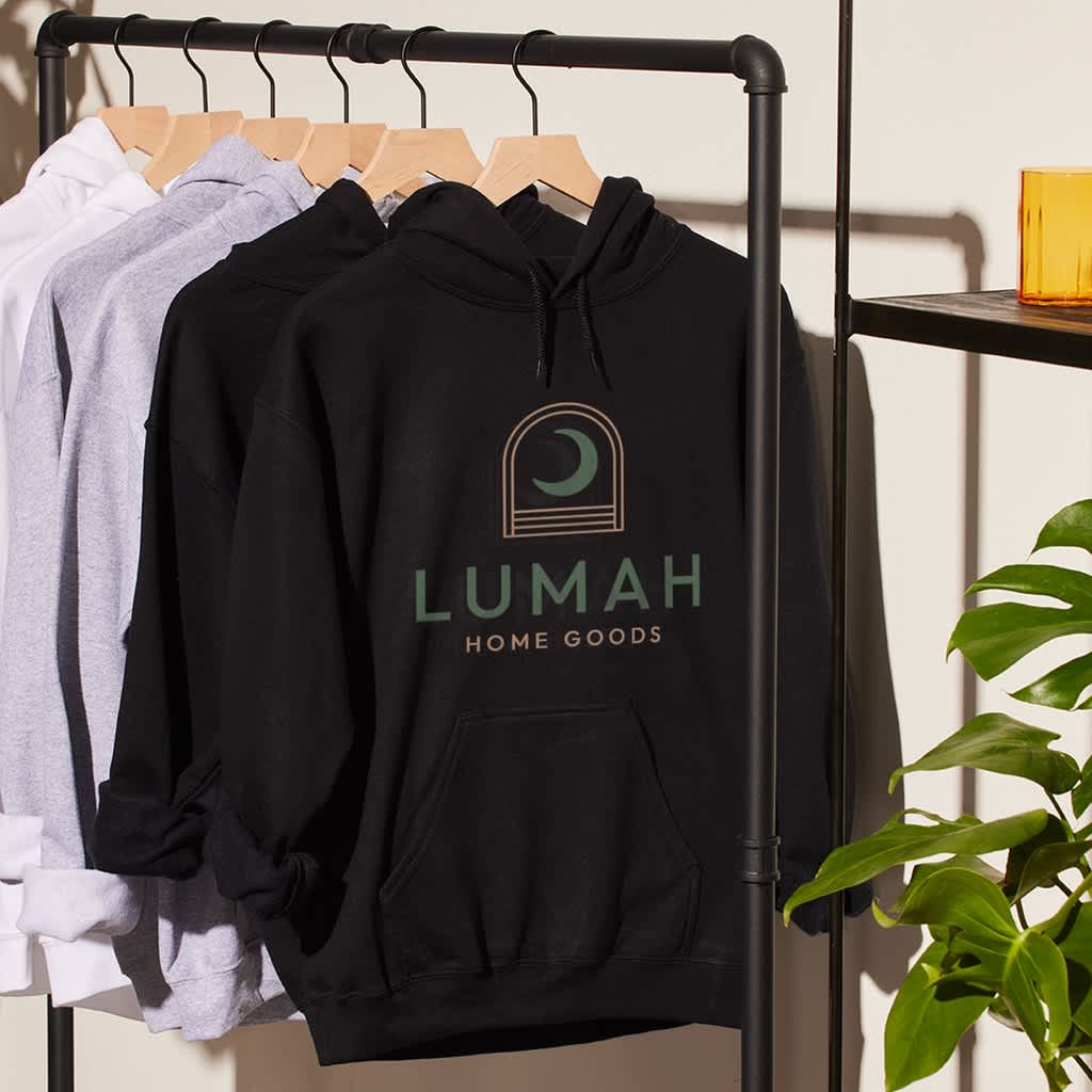 A rack with branded black, grey and white hoodies for a home goods company