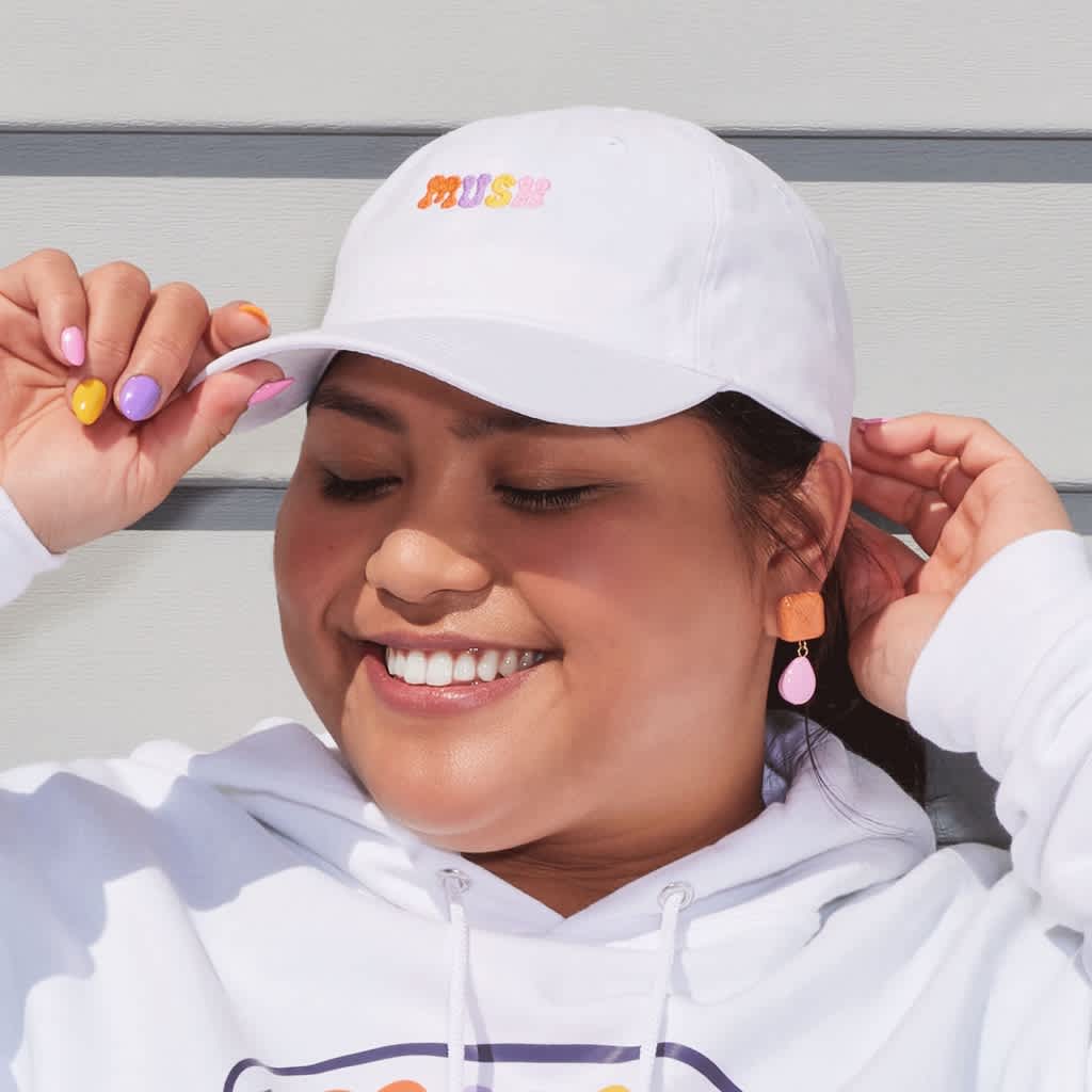 Smiling woman wearing branded white cap with colorful embroidered logo