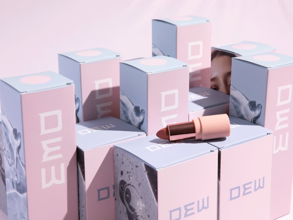 Branded blue and pink cardboard boxes in different sizes with a red lipstick on top.