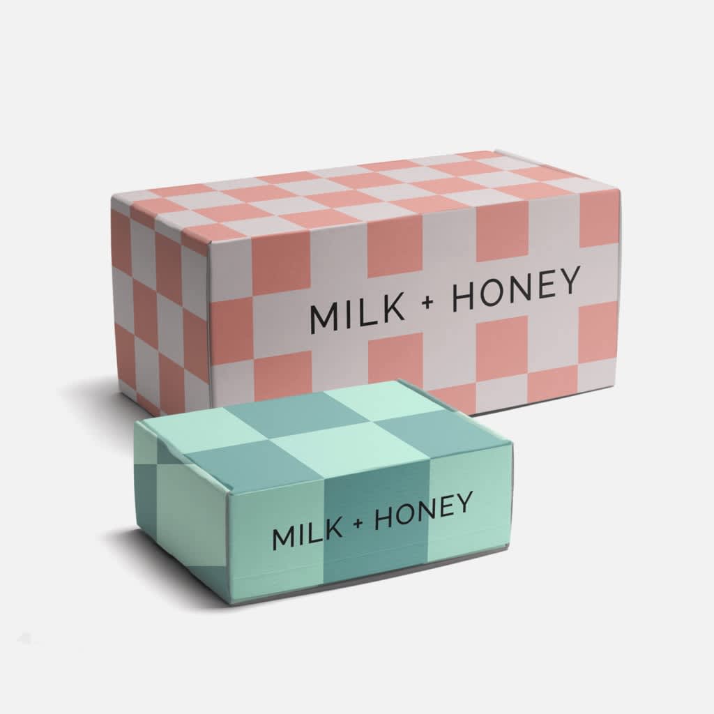 A arge pink checkerboard cardboard box and a smaller green checkerboard box featuring a brand logo.