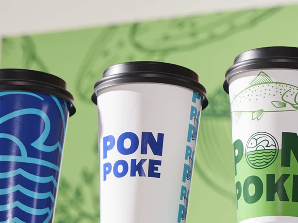 Paper cups with blue and green restaurant branding with fish illustrations and bold logo.