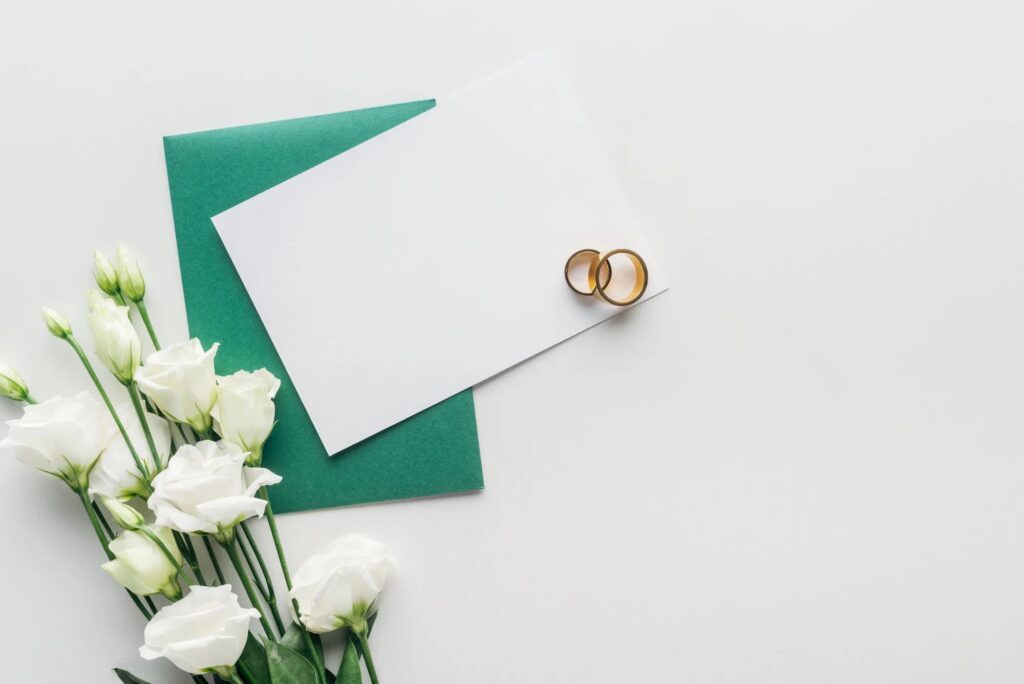 A wedding card with rings and flowers
