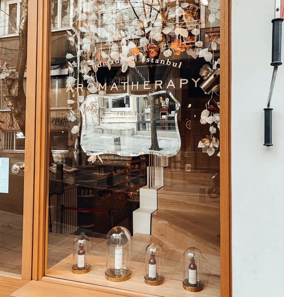 Shop display window with decorations and products in glass containers.