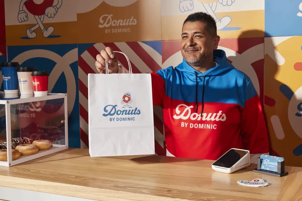 A person holding a branded paper bag.