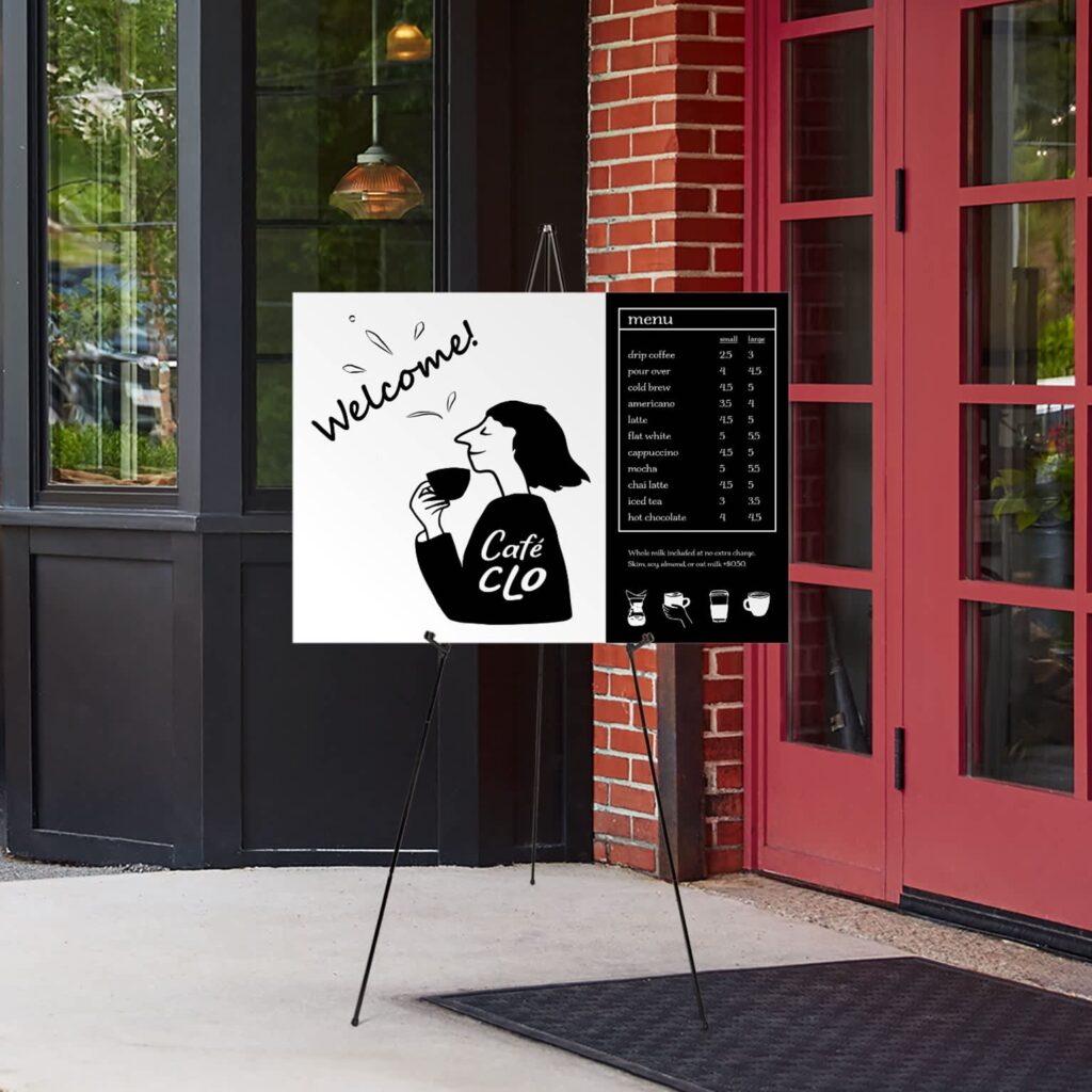 Black and white welcome sign outside a cafe with graphic of person drinking coffee.